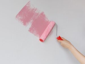 ピンクの塗料をローラーで伸ばしてる様子